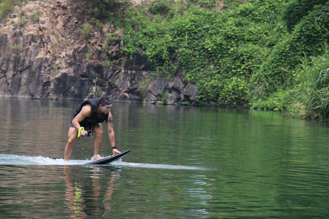 Rider getting ready to start foiling on a peaceful lake with calm reflections.