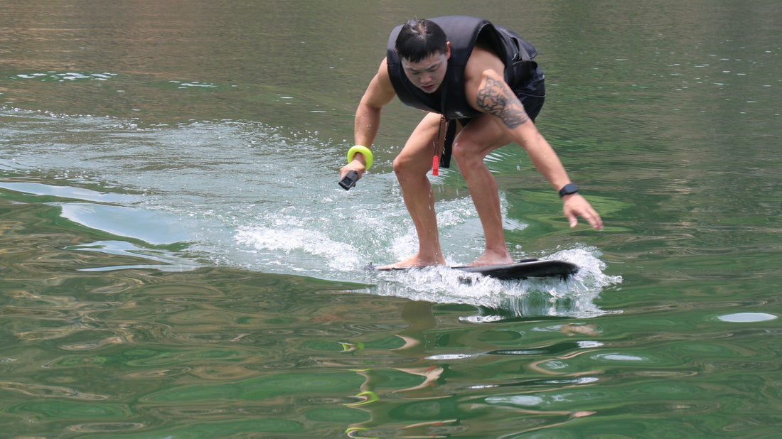 A tattooed man leans into the ride, mastering an electric hydrofoil atop glistening green waters.