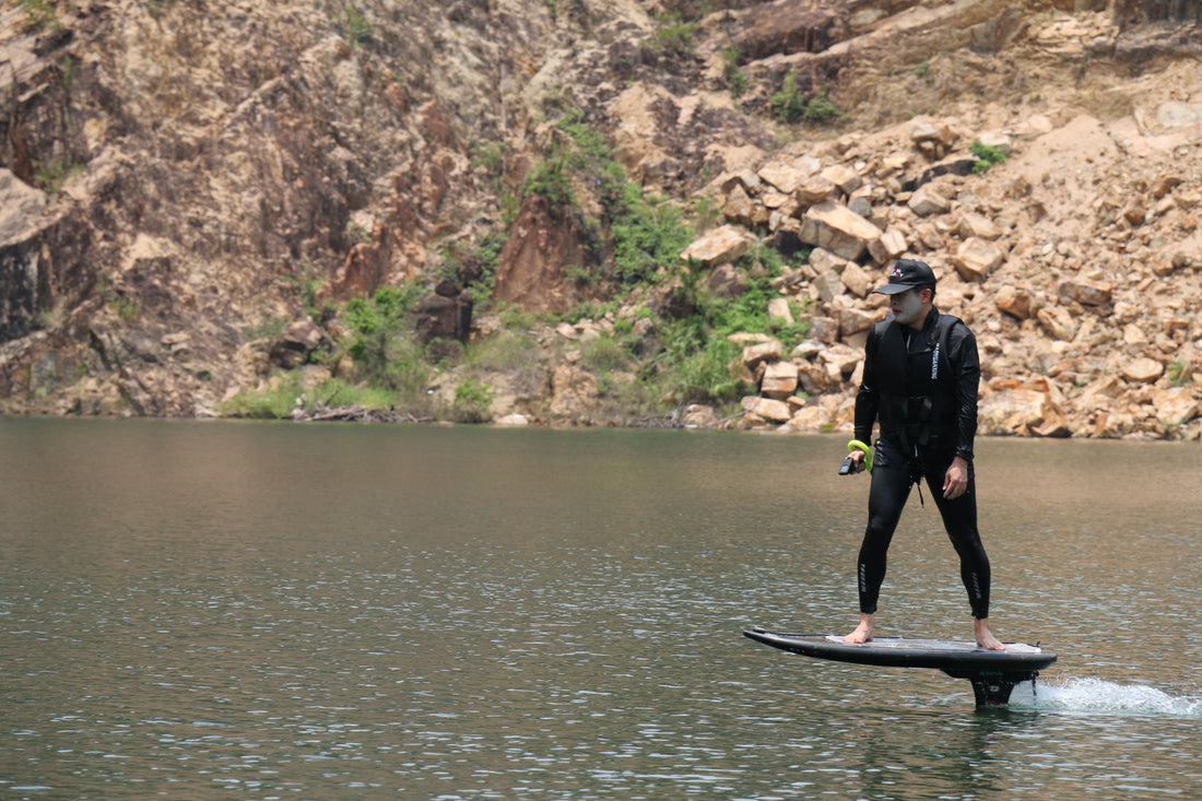 Rider gliding smoothly above calm lake on ASUFUN electric hydrofoil, showcasing silent power and futuristic water freedom.