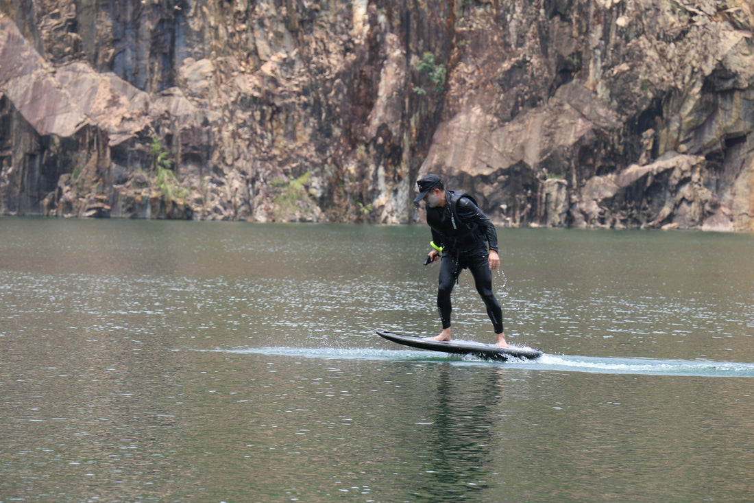 A beginner training on an electric hydrofoil over a calm lake