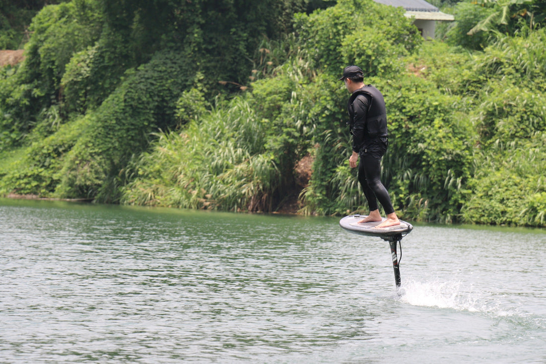 A rider gliding on an electric hydrofoil over still water, training steadily in peaceful conditions.