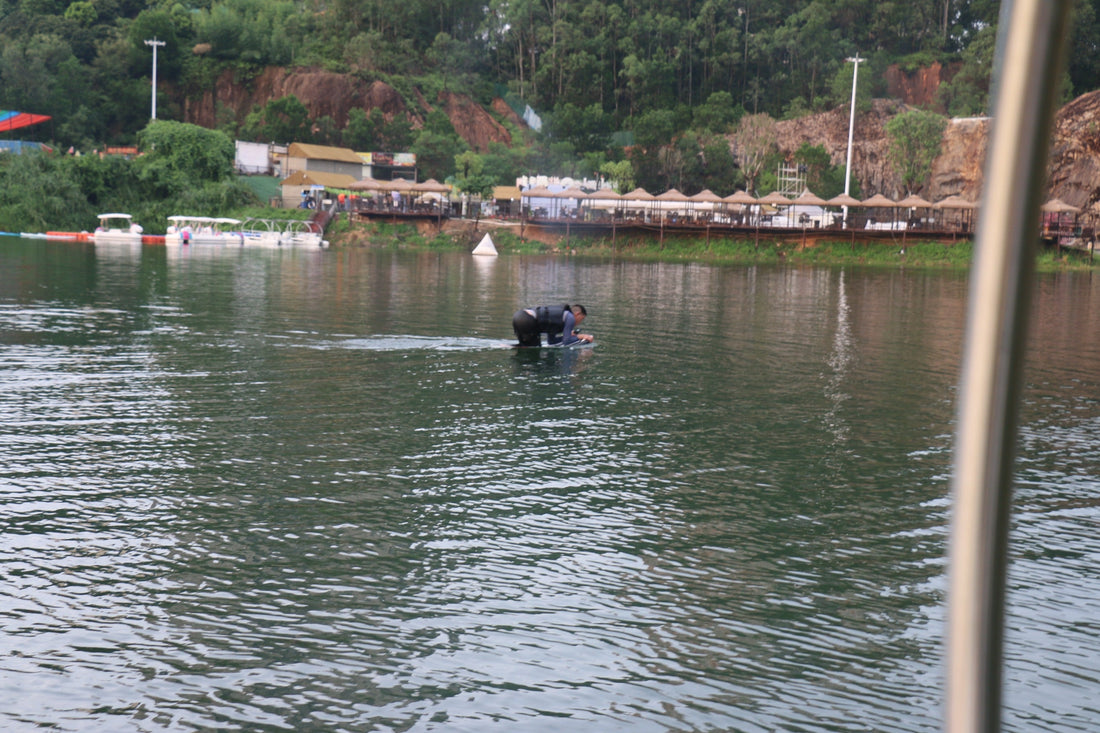 Beginner kneeling on electric surfboard during calm water practice session