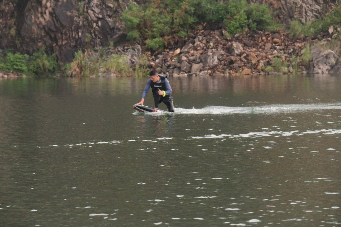 Rider testing ASUFUN foil drive against competitor systems on the water for speed, control, and smoothness.