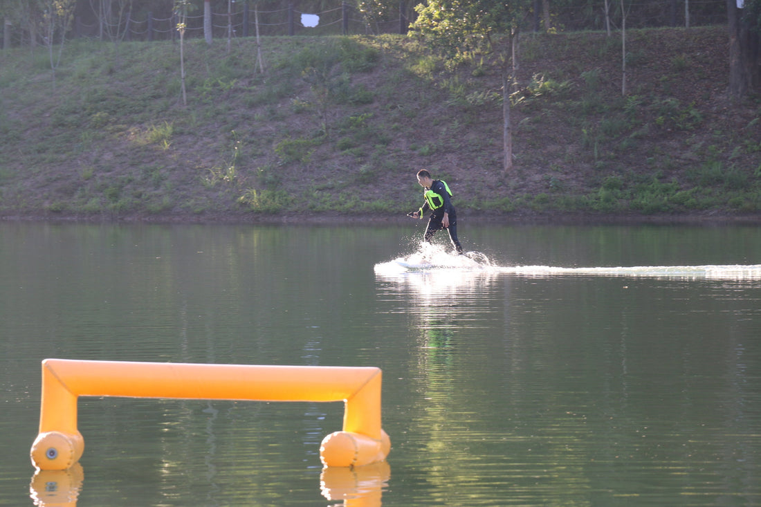 Beginner gliding smoothly on ASUFUN electric hydrofoil board over calm lake water.