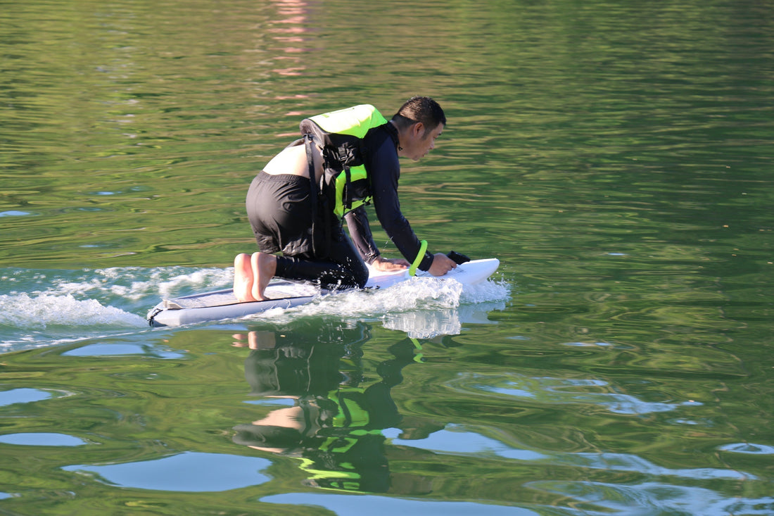 A person gliding across calm water on a self propelled hydrofoil, enjoying a smooth and effortless ride.