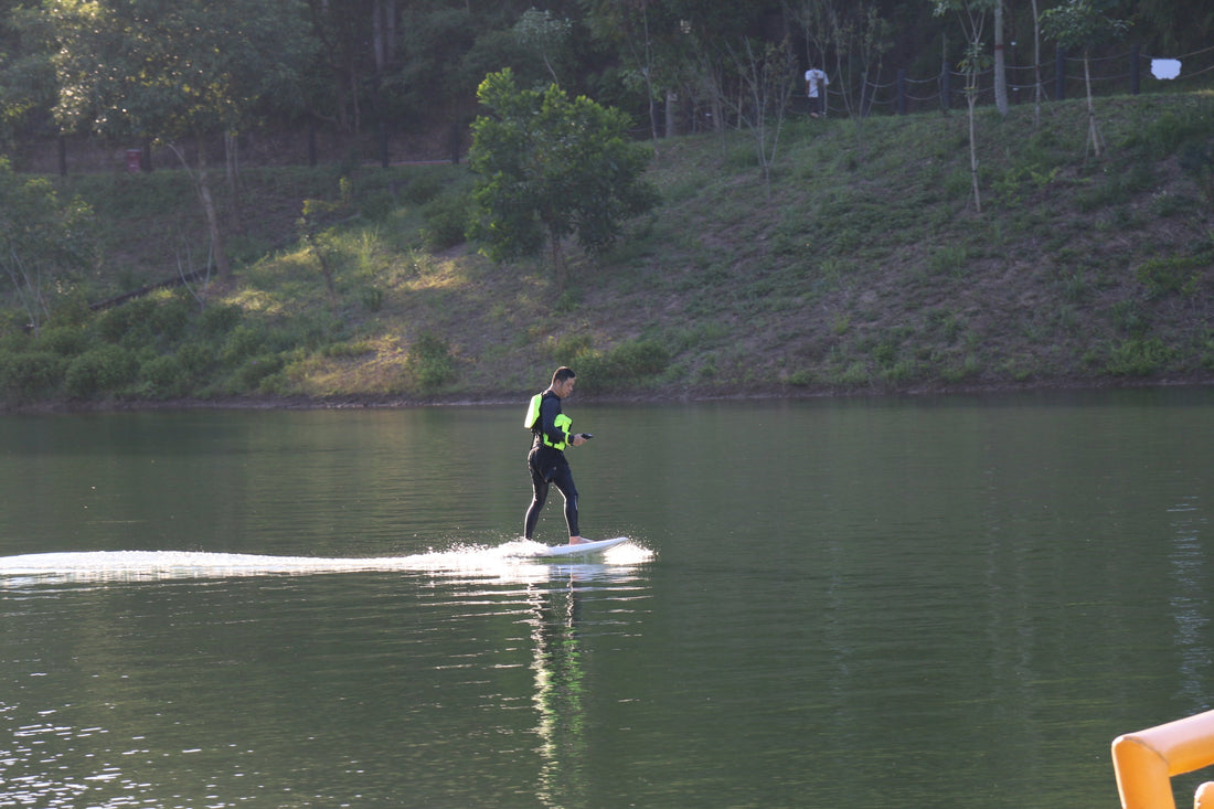 An electric hydrofoil enthusiast gliding freely on a calm lake, enjoying the Free Foiler experience