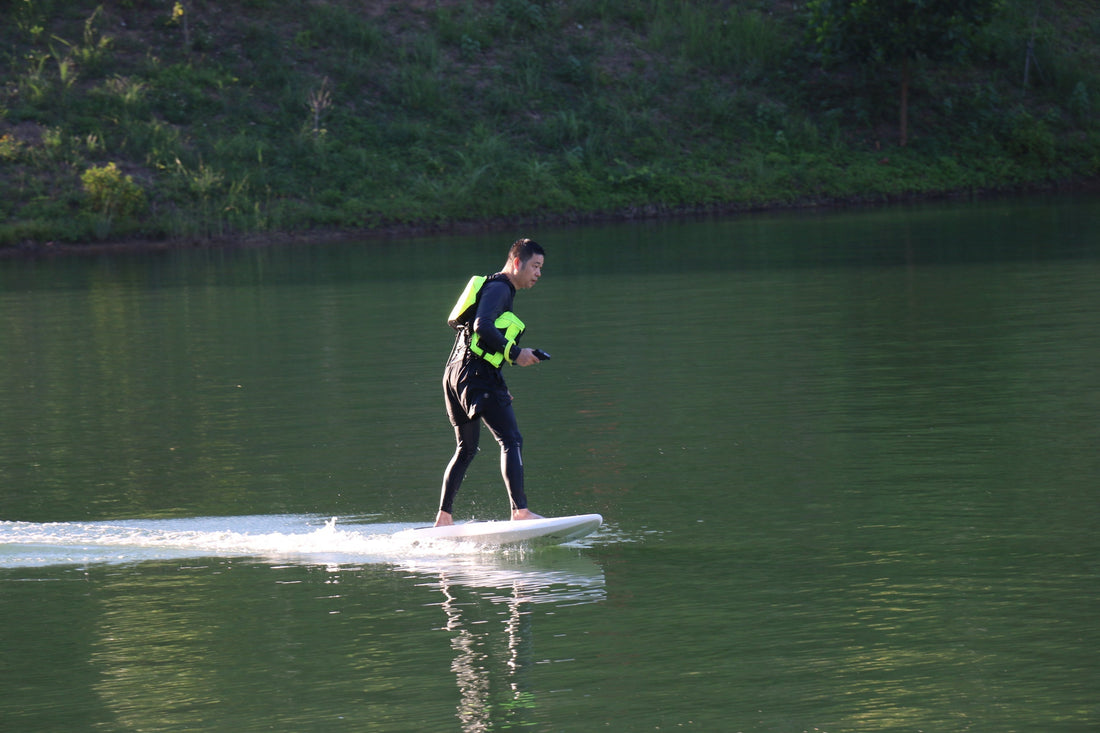 A rider training on an e-foil over glass-smooth water, mastering balance on a quiet, wave-free sea.