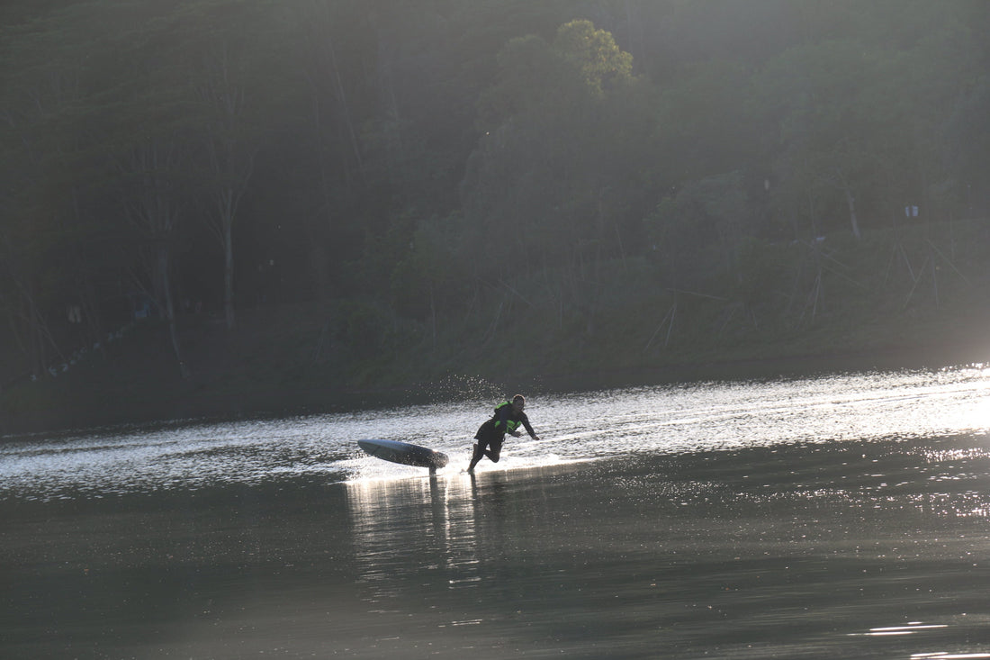 An electric hydrofoil beginner falling into the water while practicing balance